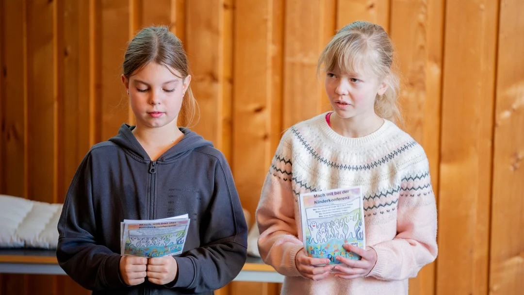 zwei kinder sprechen vor publikum