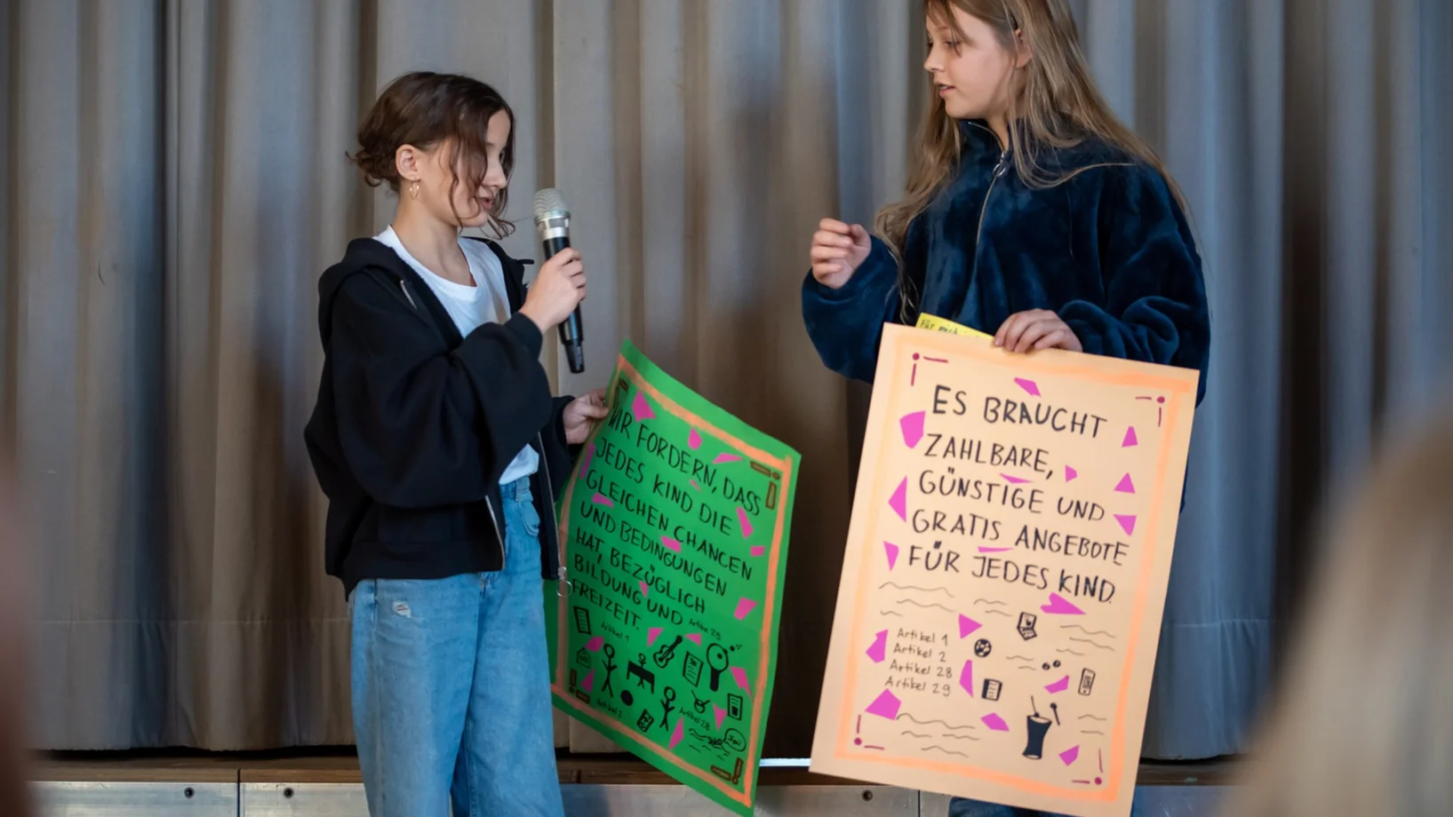 Zwei Kinder stehen auf der Bühne. Sie besuchen ein Projekt des Kinderdorfs Pestalozzi in Trogen.