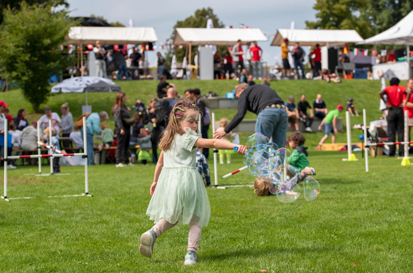 Mädchen spielt mit Seifenblasen am Sommerfest im Kinderdorf Pestalozzi in Trogen